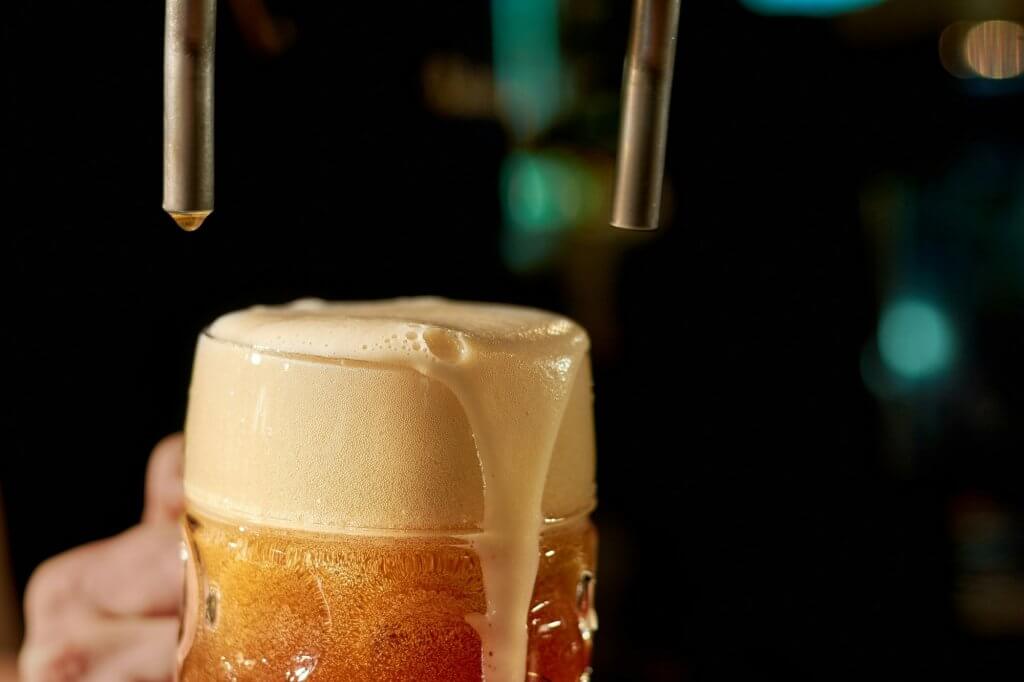 Barman pouring fresh beer in night club